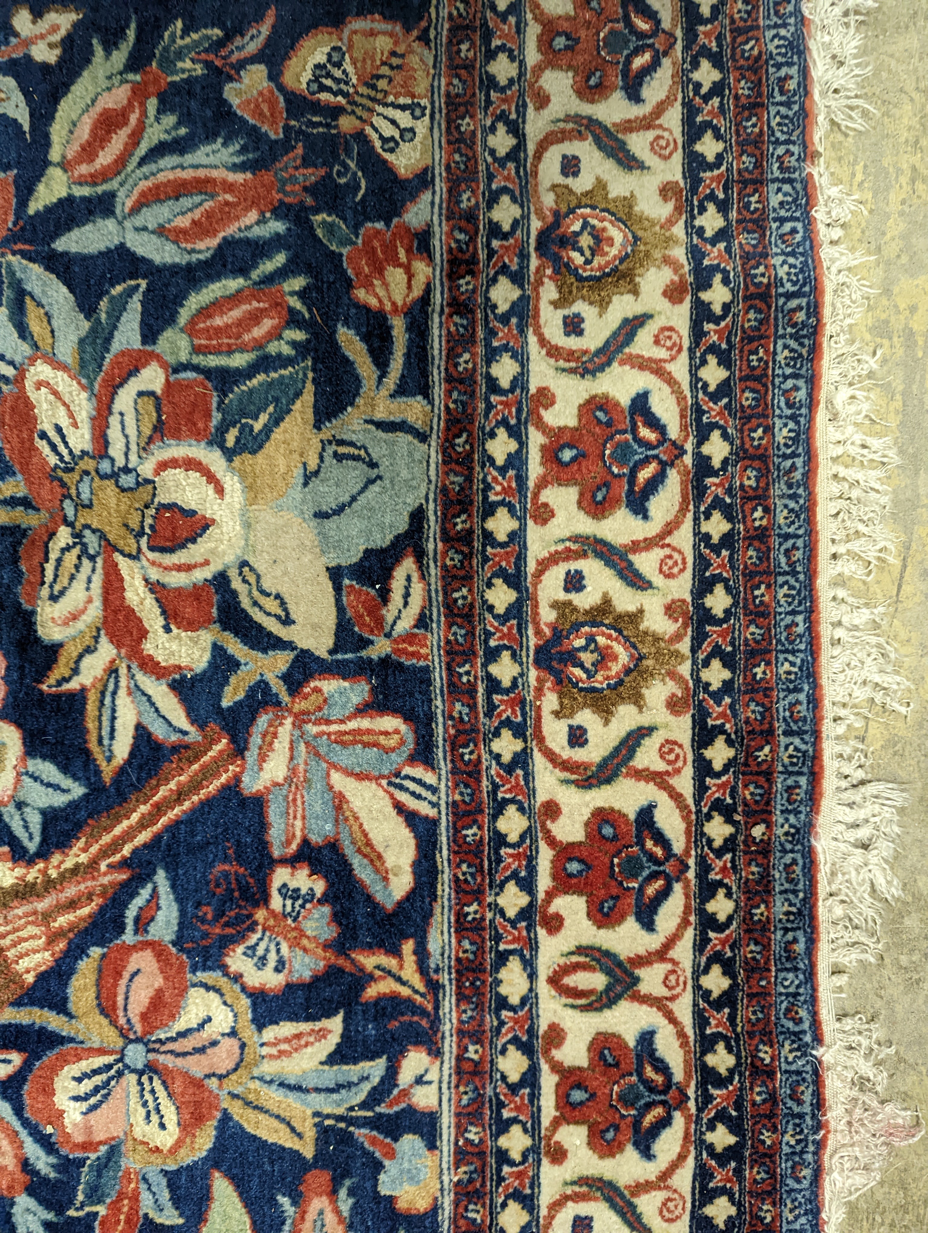 A Kirman blue ground rug woven with birds amongst flowering branches, 205 x 136cm